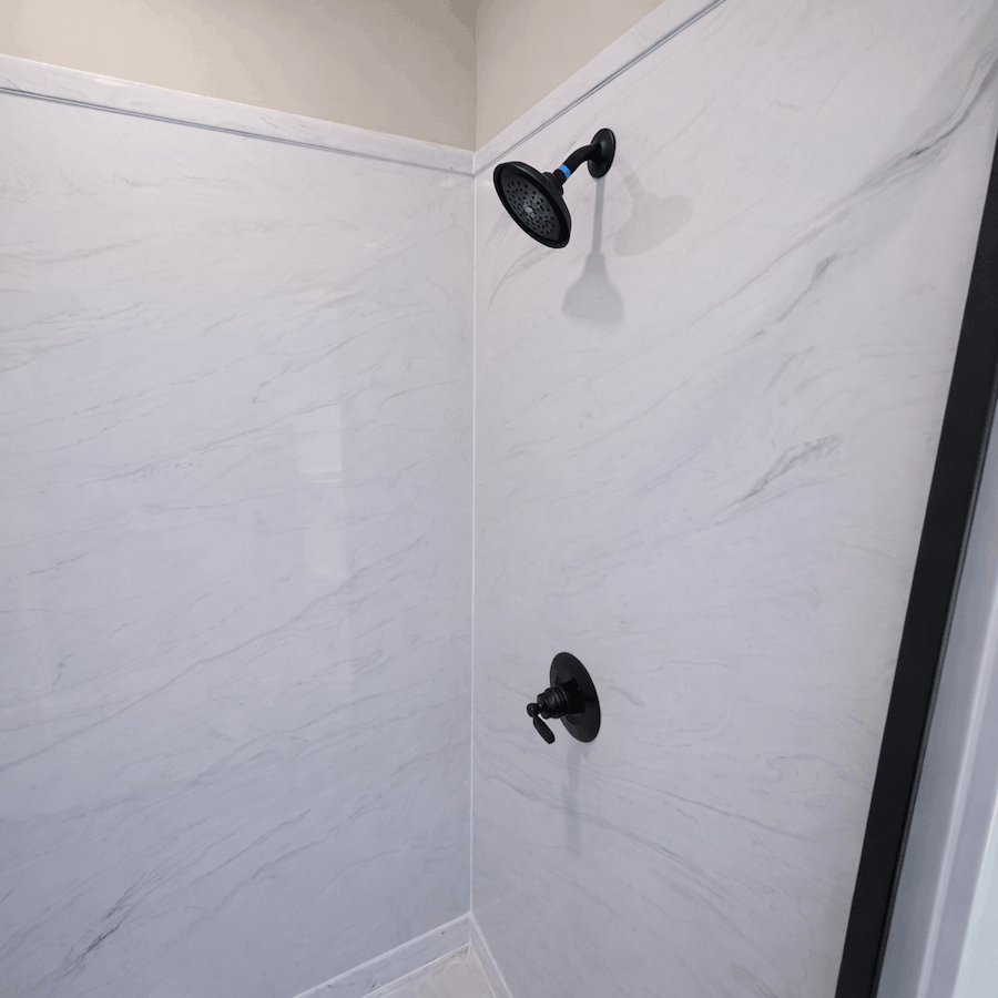 Modern shower installation with cast marble wall panels